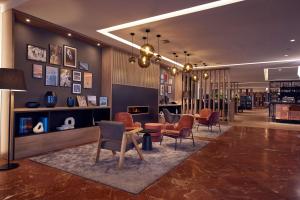汉诺威DoubleTree by Hilton Hannover Schweizerhof的大楼内摆放着桌椅的大厅 更多37张照片