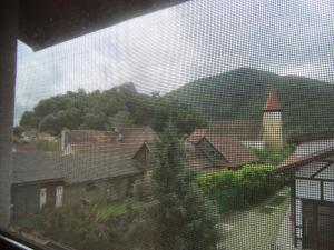 una ventana de una casa con vistas a la ciudad en Pensiunea Gasthof Michelsberg, en Cisnădioara