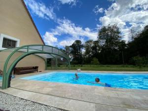 zwei Personen in einem Pool unter einem Torbogen in der Unterkunft Belle dépendance du château : LE LOGIS in Ardentes