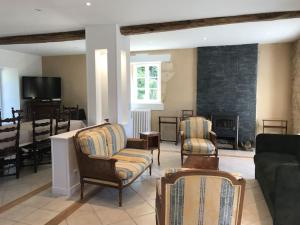 ein Wohnzimmer mit einem Sofa, Stühlen und einem Kamin in der Unterkunft Belle dépendance du château : LE LOGIS in Ardentes