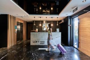 a woman walking through a lobby with her luggage at Loft 1502 in Antalya