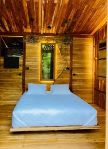 ein großes Bett in einem Zimmer mit Holzdecke in der Unterkunft Tamarindo Pura Selva Eco Tree House in Guatemala