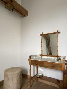 einen Schminktisch mit einem Spiegel und einem Stuhl in der Unterkunft La Cour Verte Chambres d'Hôtes in Montépilloy