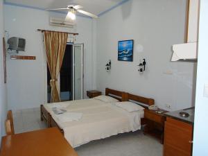 a bedroom with a bed and a table and a desk at Hotel Asteria in Agios Kirykos