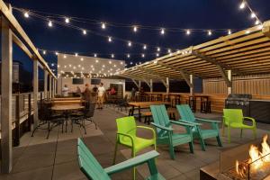 a patio with green chairs and tables and lights at Home2 Suites By Hilton Minneapolis University Area in Minneapolis