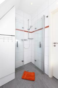 ein Badezimmer mit zwei Duschkabinen und einem orangenen Teppich in der Unterkunft Ferienhaus Daniela in Neuharlingersiel