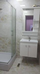 a bathroom with a sink and a shower and a mirror at Sweet home in Baku