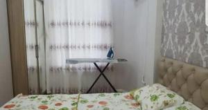 a bedroom with a bed and a desk in front of a window at Sweet home in Baku