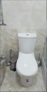 a white toilet in a bathroom with a shower at Sweet home in Baku