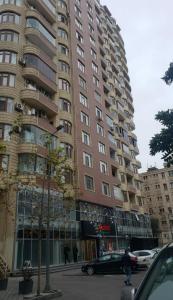 a tall building with cars parked in front of it at Sweet home in Baku