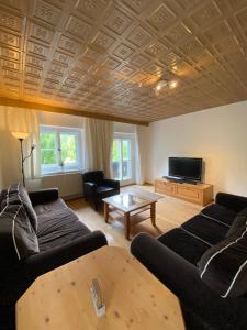 uma sala de estar com um sofá e uma mesa em Forsthaus Reit im Winkl em Reit im Winkl