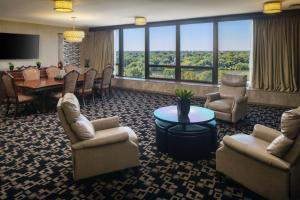 DoubleTree by Hilton Cherry Hill Philadelphia في شيري هيل: غرفة معيشة مع كراسي وطاولة وغرفة طعام