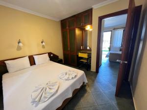 a bedroom with a bed with two towels on it at Grenadine Lodge in Dalyan