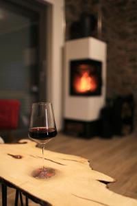 a glass of wine sitting on a table with a fireplace at Eifelvilla zur Kirsche - Wellness und Spa in Burbach