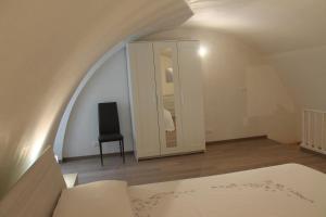 Habitación con espejo, cama y silla en Casetta Pisanelli 25, en Mottola