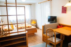 ein kleines Wohnzimmer mit einem Bett und einem Tisch in der Unterkunft Appartement Thanei in Burgeis