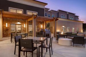 un patio con mesas, sillas y una parrilla en Homewood Suites By Hilton Oak Creek Milwaukee en Oak Creek