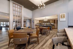 a dining room and living room with a table and chairs at Homewood Suites By Hilton Oak Creek Milwaukee in Oak Creek