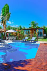 a swimming pool with benches in a resort at Villaê Pousada in Pirenópolis