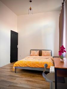 een slaapkamer met een bed, een tafel en een stoel bij Chambre privée in Roubaix