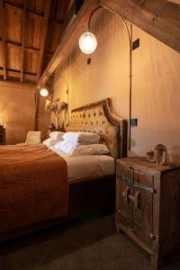 a bedroom with a bed with a wooden headboard and a table at B&B Slapen bij DKW in Oldebroek