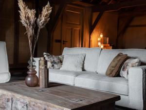 a living room with a couch and a coffee table at B&B Slapen bij DKW in Oldebroek