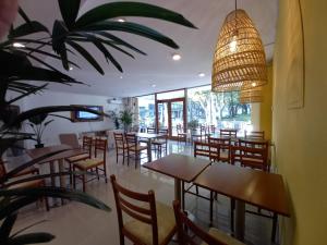 a restaurant with tables and chairs and a potted plant at Nuevo Hotel Plaza in Minas
