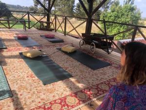 a woman is looking at a group of yoga mats at Ponte Pedra Melides -Nature & Ocean- Adults Only in Melides