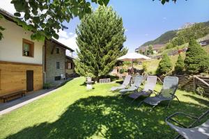 a group of chairs sitting on the grass with an umbrella at Maison Grange 2 in Gressan