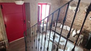 a staircase with a red door next to a room with a bed at A Casiña de Carmen in Boiro