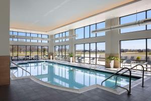 a swimming pool in a building with windows at Embassy Suites By Hilton Bowling Green in Bowling Green