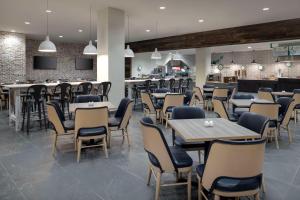 ein Restaurant mit Tischen und Stühlen und eine Bar in der Unterkunft Embassy Suites By Hilton Bowling Green in Bowling Green