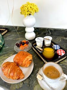 a table with a breakfast of croissants and a cup of coffee at Logis de l'Héronière in Salles-sur-Mer