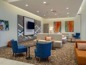 a waiting room with blue chairs and a couch at Hilton Garden Inn Jeffersonville, In in Jeffersonville