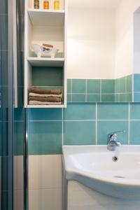 a bathroom with a white sink and blue tiles at Casa dei Ré in Siracusa