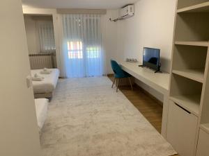 Kleines Zimmer mit einem Schreibtisch und einem TV. in der Unterkunft Royal L Hotel in Carev Dvor