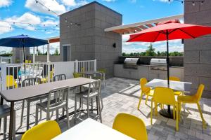 a patio with tables and chairs and umbrellas at Home2 Suites By Hilton Wildwood The Villages in Wildwood