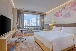 a hotel room with a bed and a couch at Hilton Garden Inn Shenzhen Guangming in Shenzhen