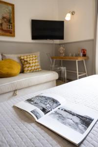 a book on a bed with a couch in a room at Casa dei Ré in Siracusa