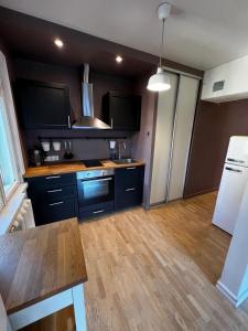 a kitchen with black cabinets and a wooden floor at Videviku Apartments in Tallinn