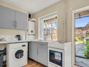 a kitchen with a washer and dryer next to a window at Pass the Keys A Period Building in the Heart of Canterbury in Canterbury