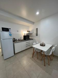 a kitchen with a white refrigerator and a table and chairs at Monoambiente H&O in Cipolletti