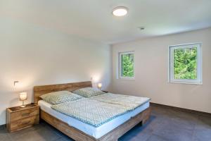 ein Schlafzimmer mit einem Bett und zwei Fenstern in der Unterkunft Haigerach in Gengenbach