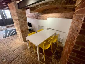 a white table and chairs in a room with a brick wall at Duplex de encanto en Part Alta! in Tarragona