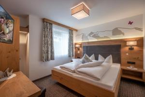 una camera con un grande letto con testiera in legno di Schöne Aussicht Apartments a Tux