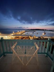 two chairs on a balcony with a view of a harbor at KR Apartments in Aliki