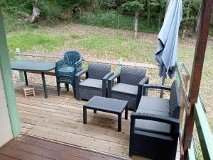 a deck with chairs and a table and a table and chairs at Chalet les Hameaux du Perrier in Lissac-sur-Couze