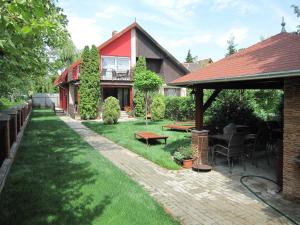 un patio con una casa con mesa y sillas en Zrínyi ház, en Szántód