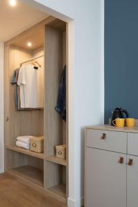 a walk in closet with wooden shelves and a white cabinet at Hampton by Hilton Rome North Fiano Romano in Fiano Romano