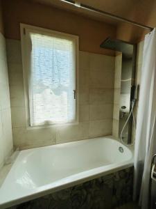 a white bath tub in a bathroom with a window at Kibilù - Via Galvani con parcheggio e giardino privato in Ispra
